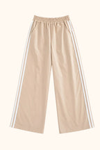 Beige wide-leg pants with an elastic waistband and white three-stripes running down the outer sides of each leg, shown flat on a white background.