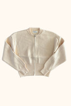 A cream-colored cropped knit zip-up sweater with ribbed collar, cuffs, and hem, displayed flat against a white background.