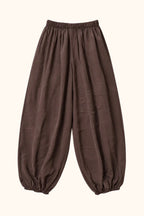 A pair of loose-fitting brown harem-style pants with an elastic waistband and gathered elastic cuffs at the ankles, shown against a plain white background.